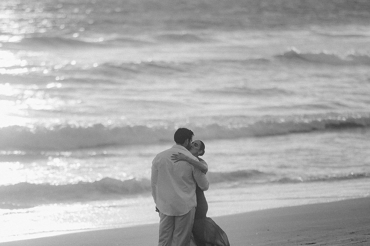 Carolina abrazando a Carlos en la playa durante una sesión en Mazatlán.