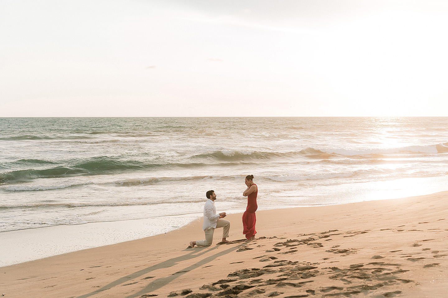 Carlos se arrodilla ante Carolina,  oficialmente proponiendo matrimonio en las playas de Mazatlán.
