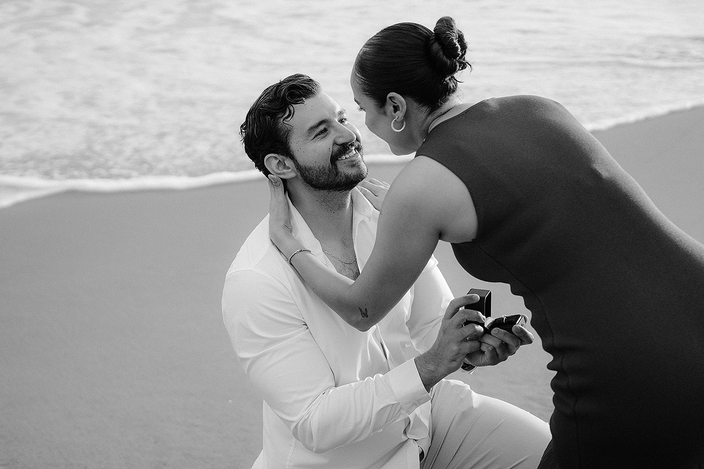 Carolina toma del cuello a Carlos demostrandole su amor a Carlos durante el proposal en las playas de Mazatlán.