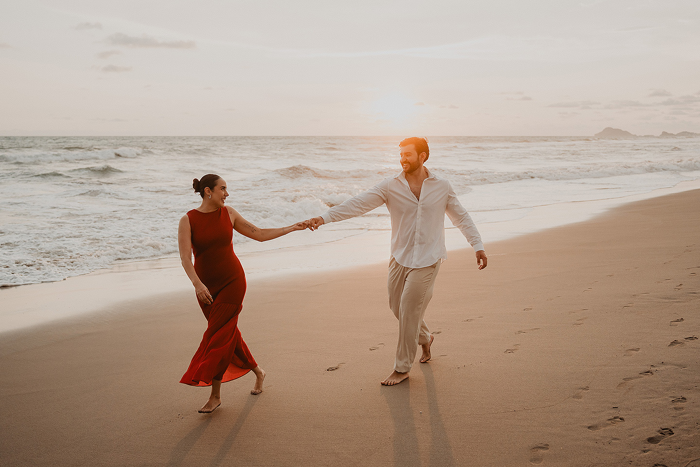 Carolina y Carlos corren durante la sesion del proposal en las playas de Mazatlán.