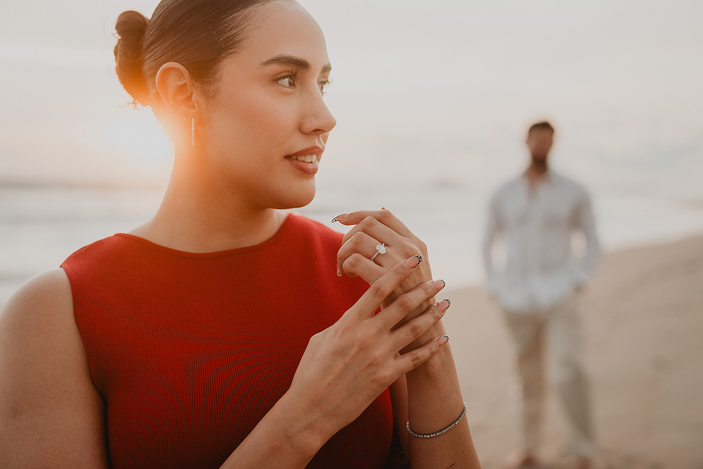 Carolina muestra el anillo de compromiso mientras Carlos esta atras de ella durante la sesion del proposal en las playas de Mazatlán.