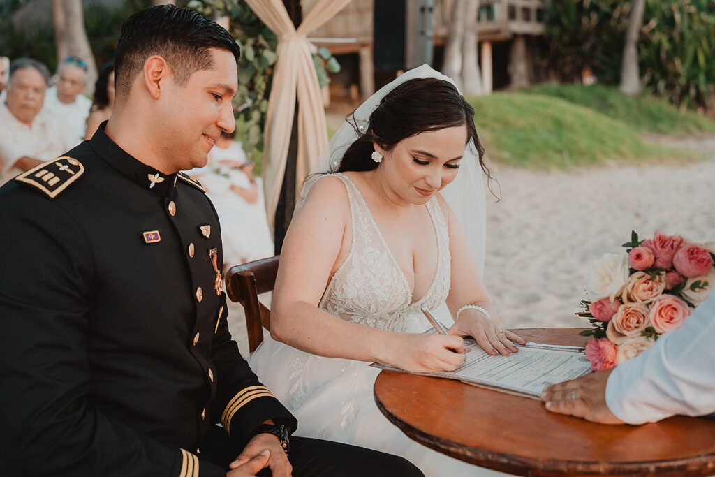Firmando el acta de la ceremonia civil en la boda de Eli y Mahatma en las playas de Mazatlán, México.