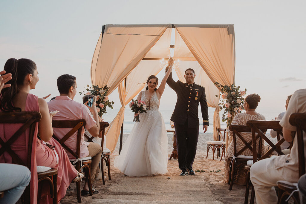Eli y Mahatma saliendo felicies, en la boda de Eli y Mahatma en las playas de Mazatlán, México.
