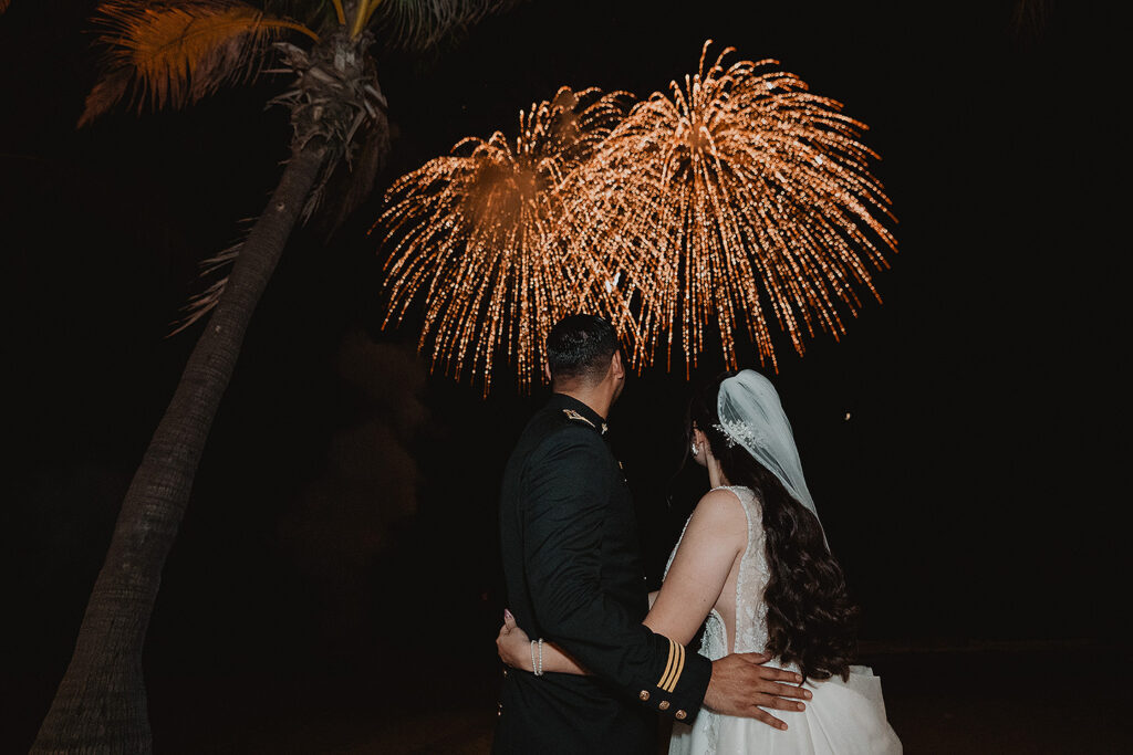Los novios viendo los fuegos articifiales, en la boda de Eli y Mahatma en las playas de Mazatlán, México.