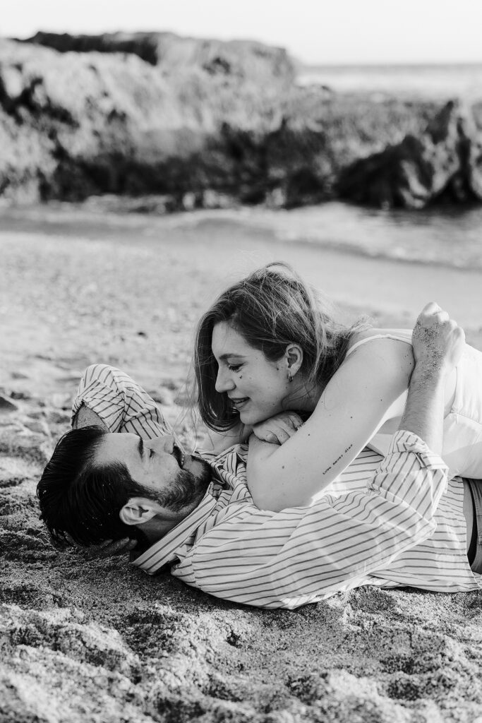 Sesión de pareja en Mazatlán de Xiomara y Alejandro junto al mar acostados en la arena
