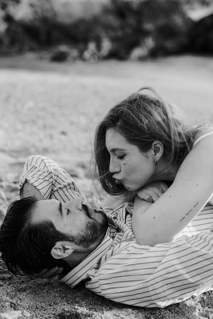 Sesión de pareja en Mazatlán de Xiomara y Alejandro junto al mar en la arena dandose un beso