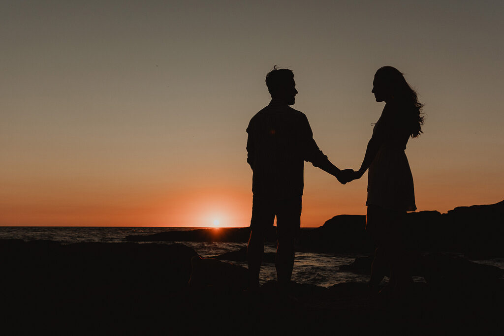 Sesión de pareja en Mazatlán de Xiomara y Alejandro junto al mar en contra luz hacia el sol