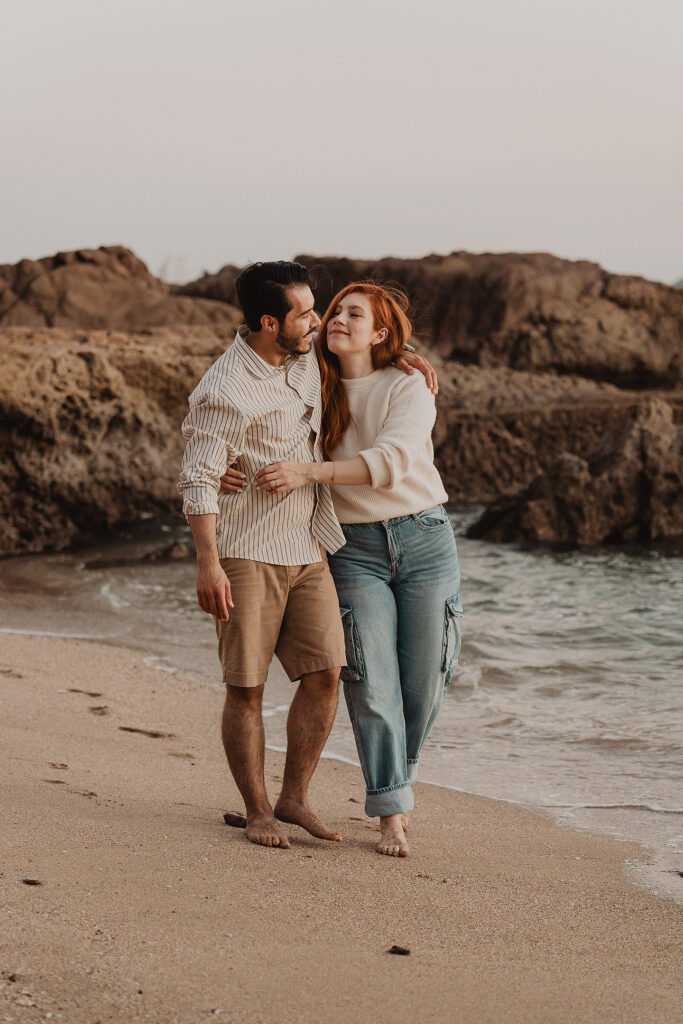 Sesión de pareja en Mazatlán de Xiomara y Alejandro junto al mar abrazados caminando por la playa